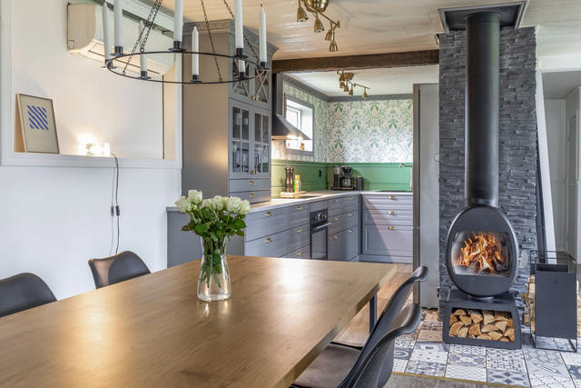 Vardagsrum med kamin och öppen planlösning till kök