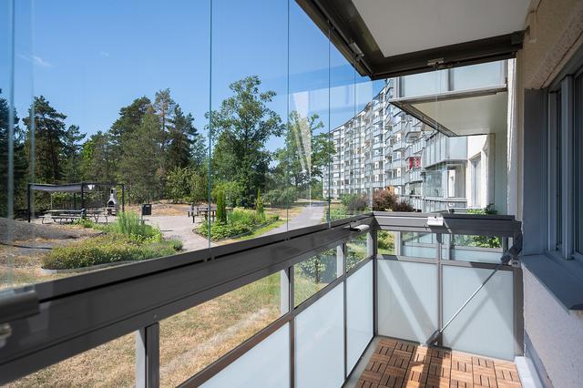Stor inglasad balkong med utsikt över föreningens innergård