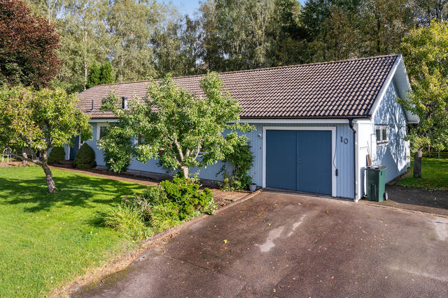 Vidbyggt garage med bakomliggande förråd.