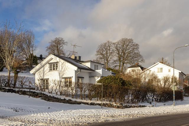 Vassevägen 1. Inramat av stenmur och häck.