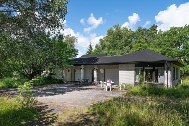 Huvudbyggnaden med dubbla garage och gästhus.