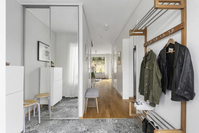 Något möblerbar hall med dubbelgarderob. Glimt mot vardagsrummet och trädgård