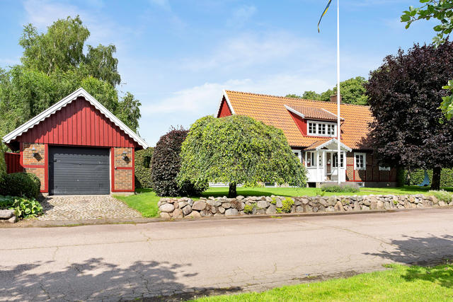 Vacker stenmur ramar in framsidan med garage och boningshus
