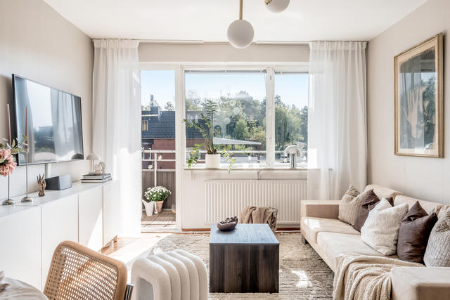 Ljust vardagsrum med utgång till balkong i söderläge