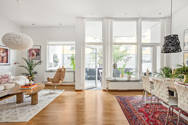 Vardagsrum med extra generös takhöjd och stora fönsterpartier mot Westerbergs gata