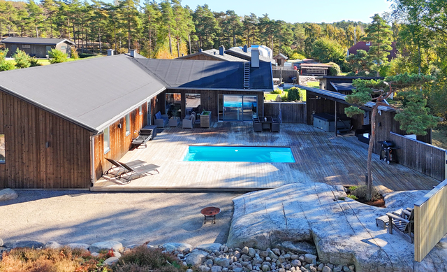 Innergård baksidan huset med pooldäck, spabad, pergola i västerläge med kvällsol,