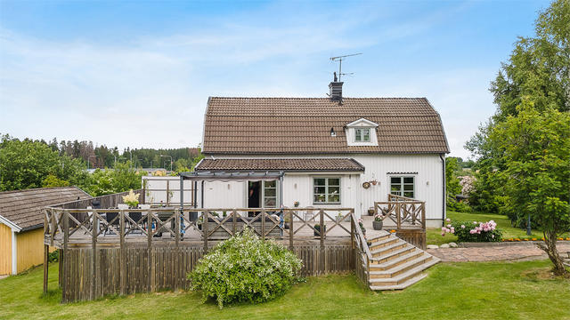 Charmig villa med härligt stor trädäckad altan samt garage till höger