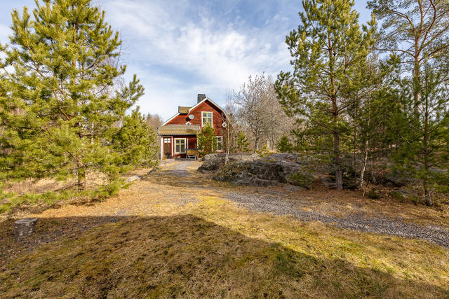 Rött hus med vita knutar på landet