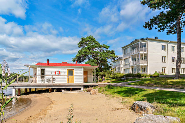 Föreningens sandstrand med båthus. Bostadshuset i bakgrunden.