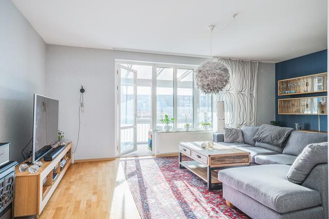 Rymligt och ljust vardagsrum med utgång till den inglasade balkongen
