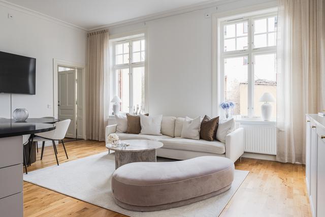 Stort vardagsrum med plats för både soffa och matbord.