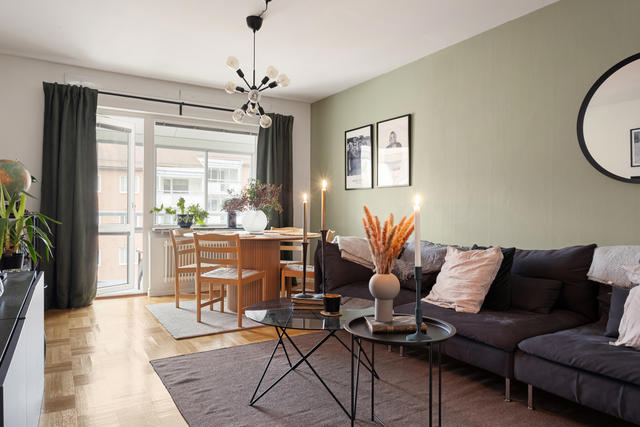 Vardagsrum med plats för både soffa och matsalsbord samt utgång till inglasad balkong