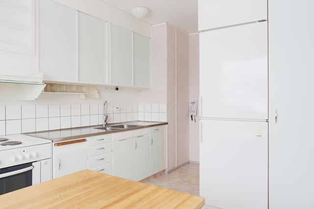 Ljust kök med rostfri diskbänk och kryddhylla