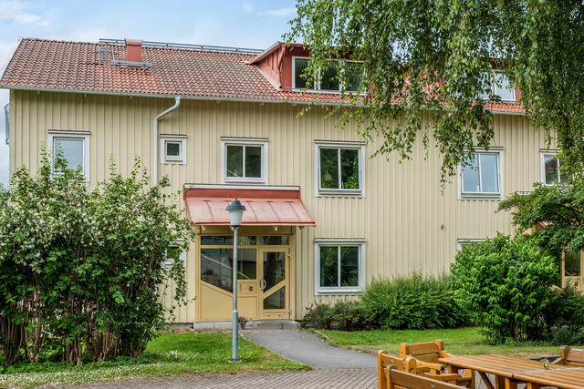 Bostadshuset ligger omgiven av grönska. (Obs bild på entrén i B-uppgång)