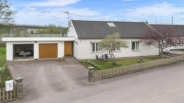 Entrésidan med garage och carport