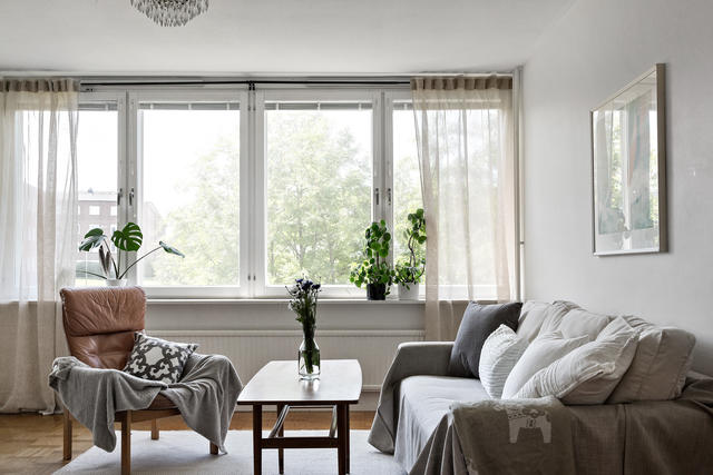 Ljust och luftigt vardagsrum med stora fönsterpartier