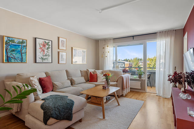 Stort luftigt vardagsrum med utgång till inglasad balkong i väst. 