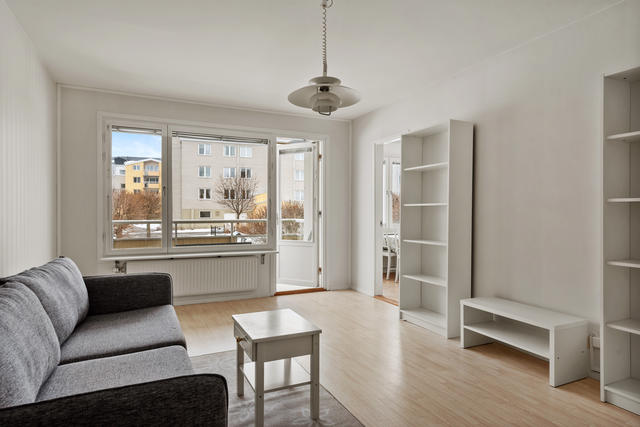 Vardagsrum mot balkong med eftermiddag/kvällssol