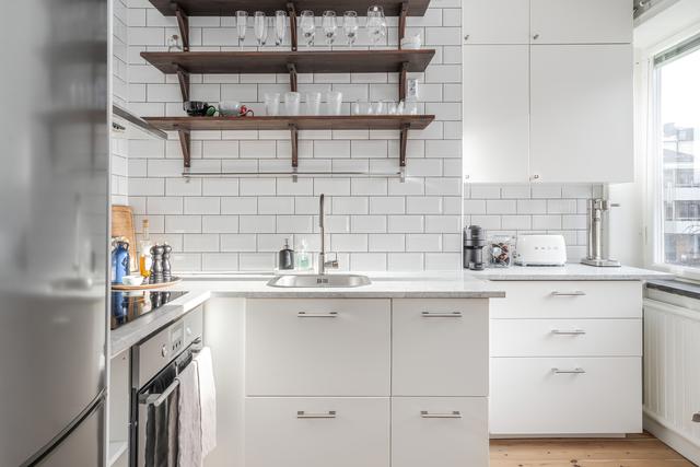 Modernt kök i vitt med kaklad vägg