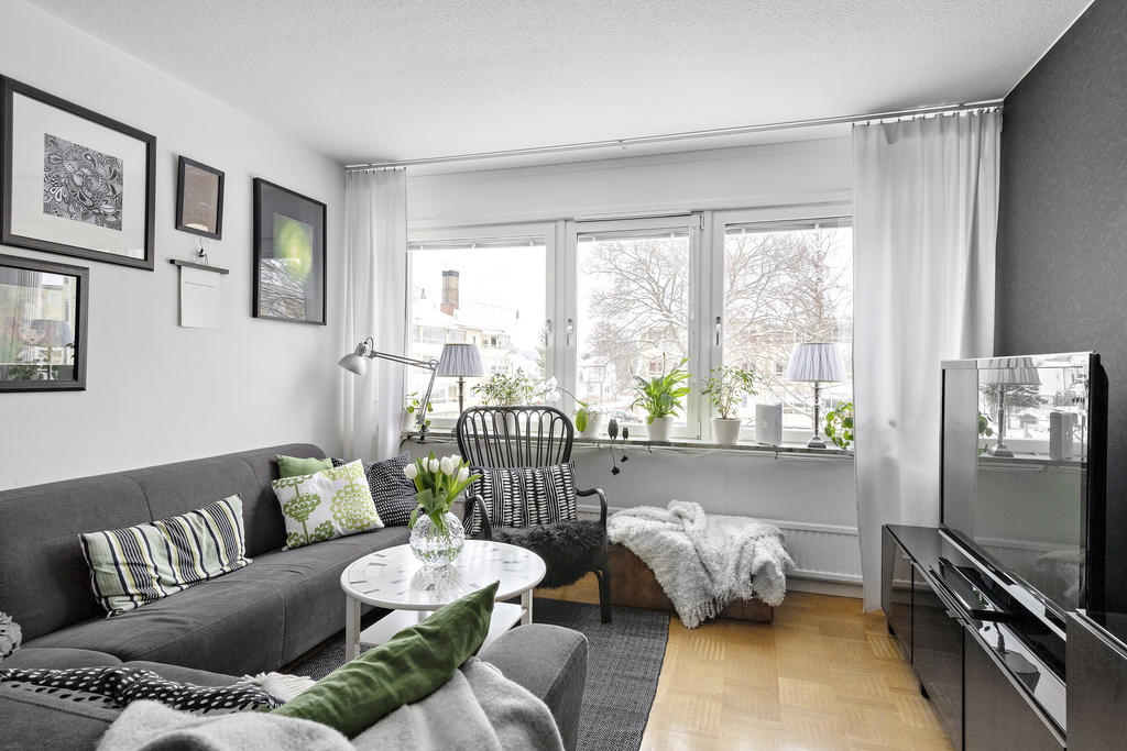 Rymligt vardagsrum med stora fönster med gott om ljusinsläpp. 