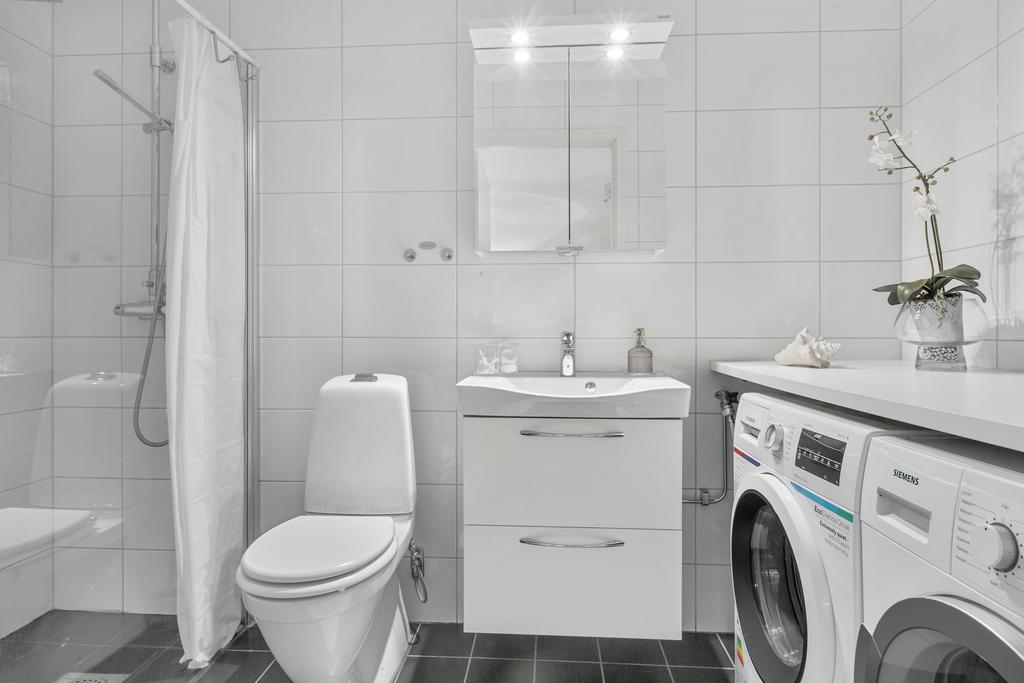 Duschrum på nedre plan med tvättmaskin och torktumlare