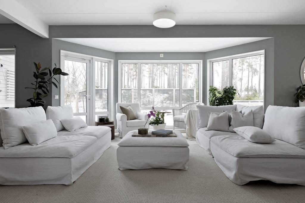 Charmigt och modernt vardagsrum som skapar känsla av rymd tack vare det stora fönsterpartiet