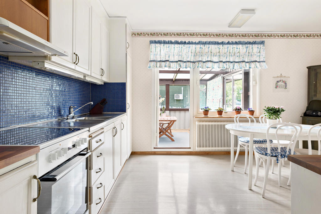 Kök med utgång till inglasat uterum.