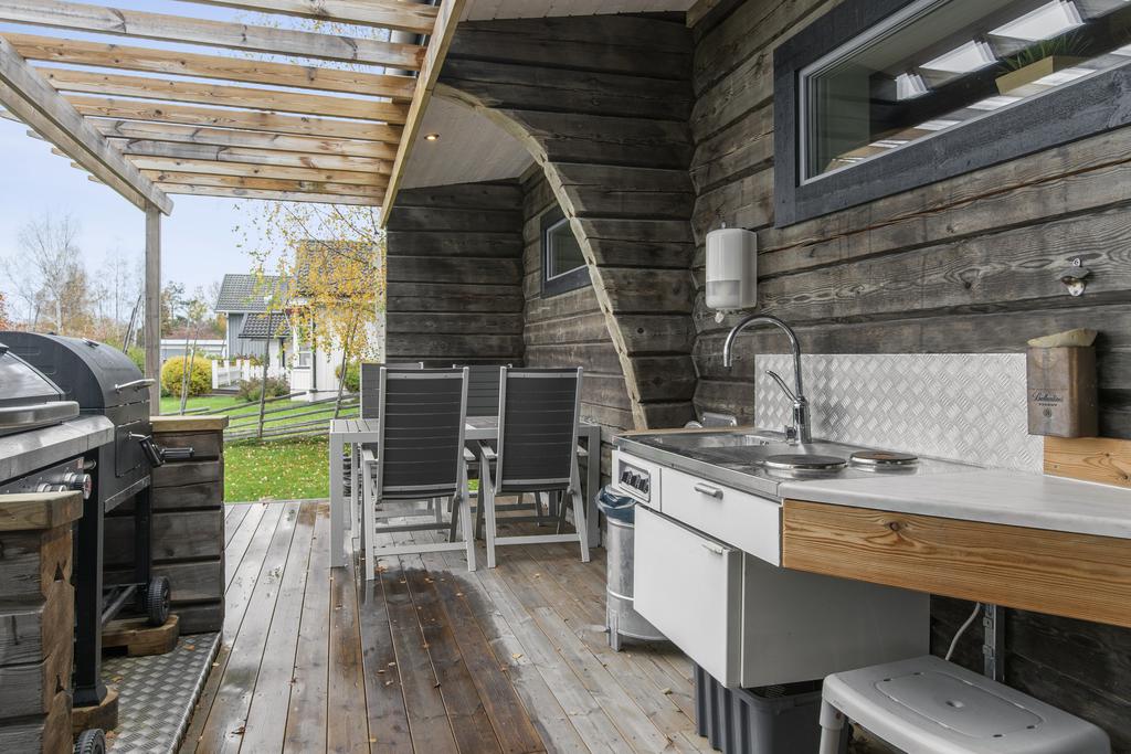 Uteplats med flera sittplatser, pergola och utekök samt ett uterum i bästa solläge.