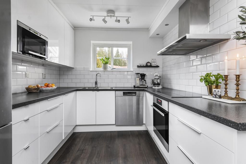 Kök i stilrent vitt med mörk bänkskiva