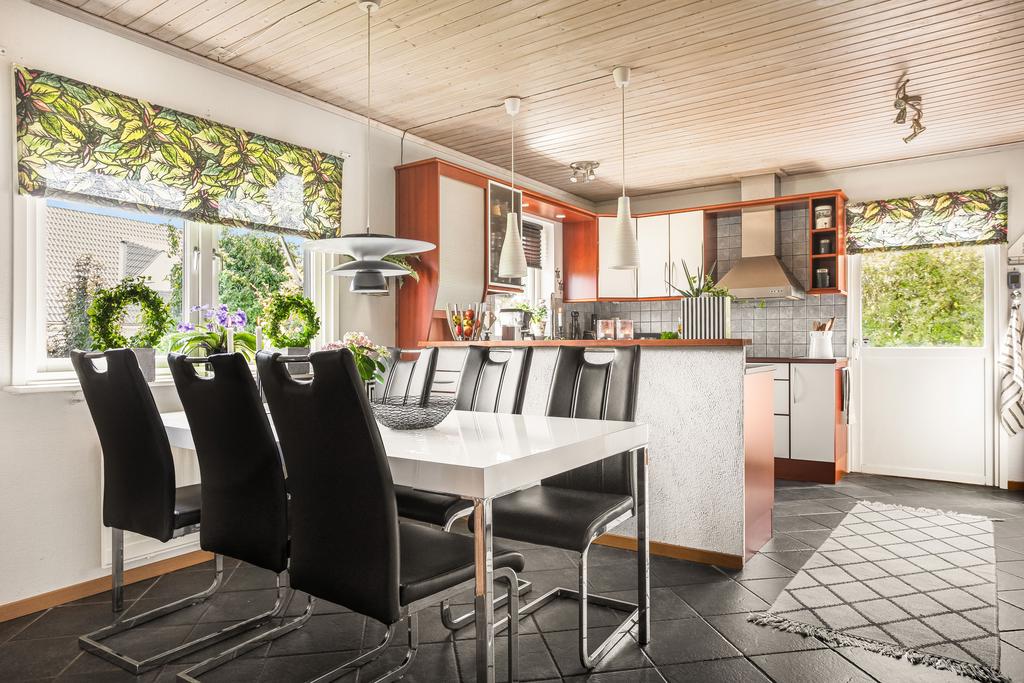 I köket finns plats för ett stort köksbord. På golvet ligger klinkers.