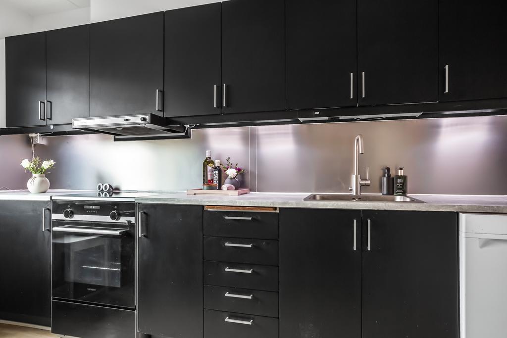 En smakfull kombination av svart inredning och rostfria detaljer i köket