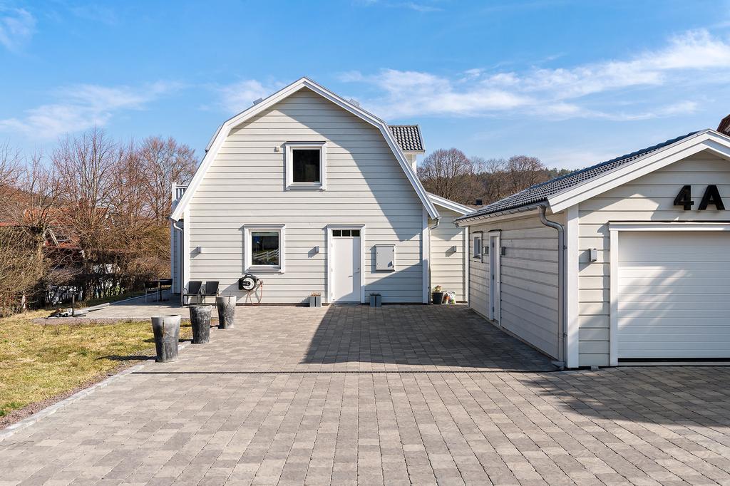 Garage och fin stenlagt parkering med gott om plats för era och vännernas bilar.