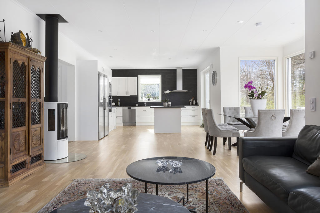 Öppen planlösning mellan kök och vardagsrum. Braskaminen bidrar till en hemtrevlig känsla