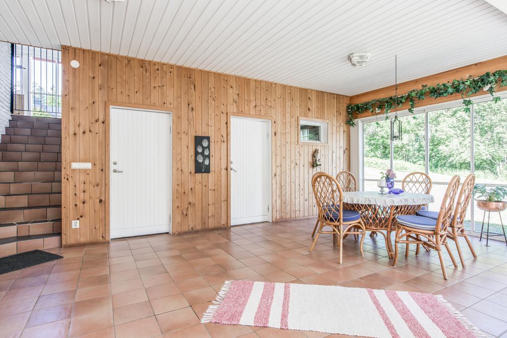 Inglasat uterum med trapp upp till uteplats vid entrén