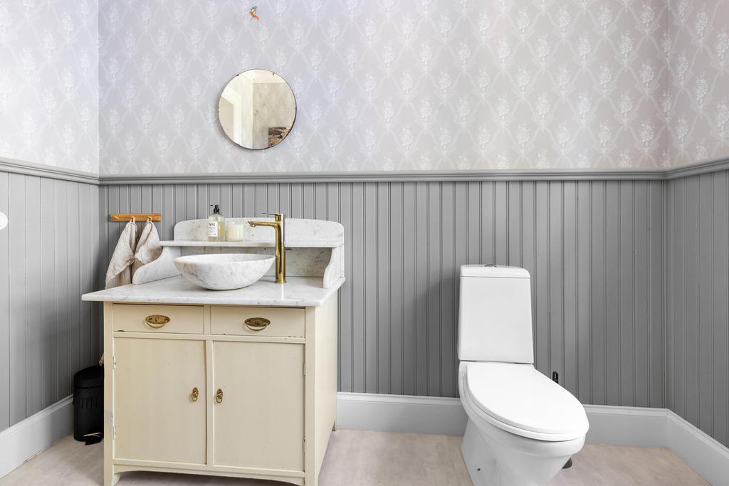 I wc-rummet finns även ett handfat, snyggt monterat på en gammal kommod