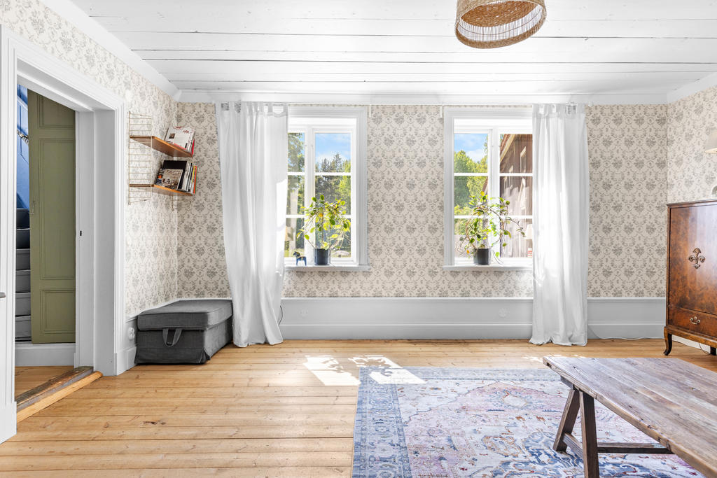 Vardagsrummet har trägolv och höga golvsocklar