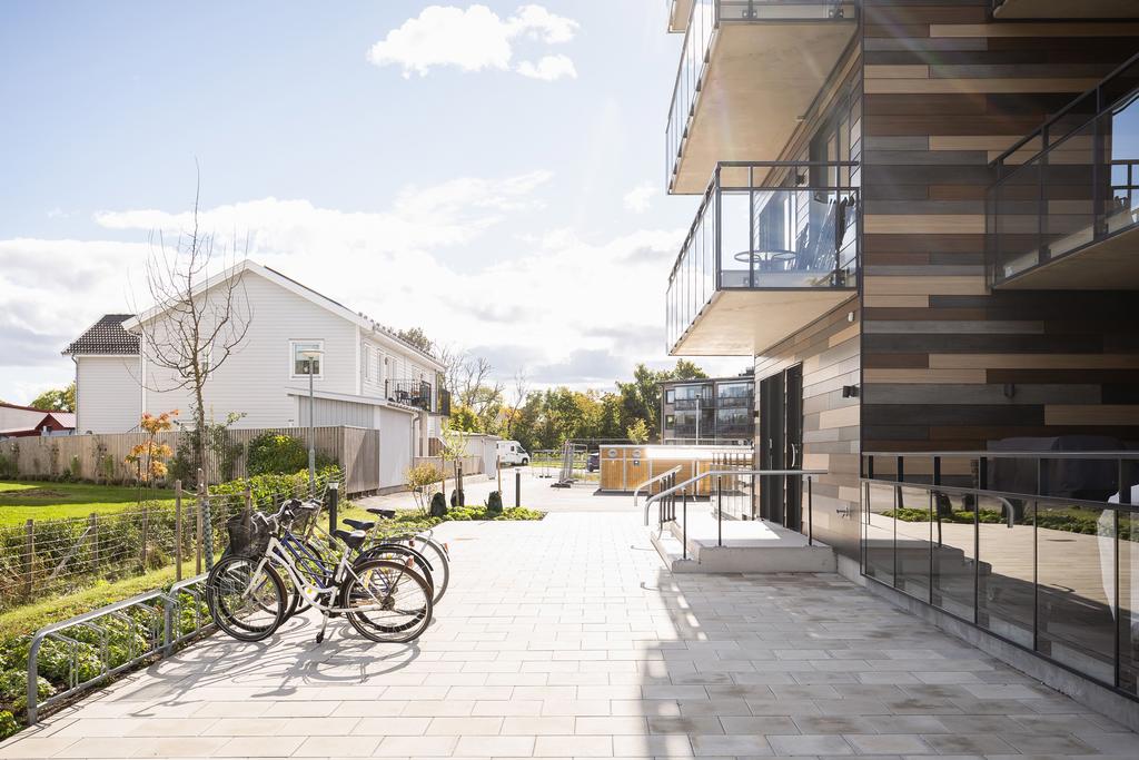 Välordnat med cykelparkering och sopsortering nära entrén till huset.