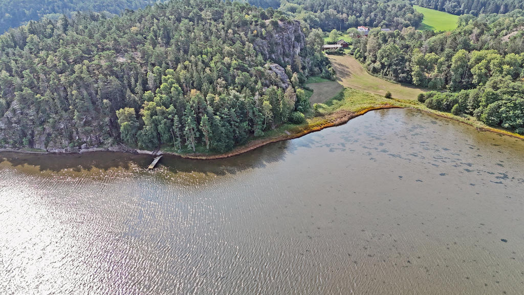 Flytbryggan med muddrad ränna till vänster  och husen till höger i bild