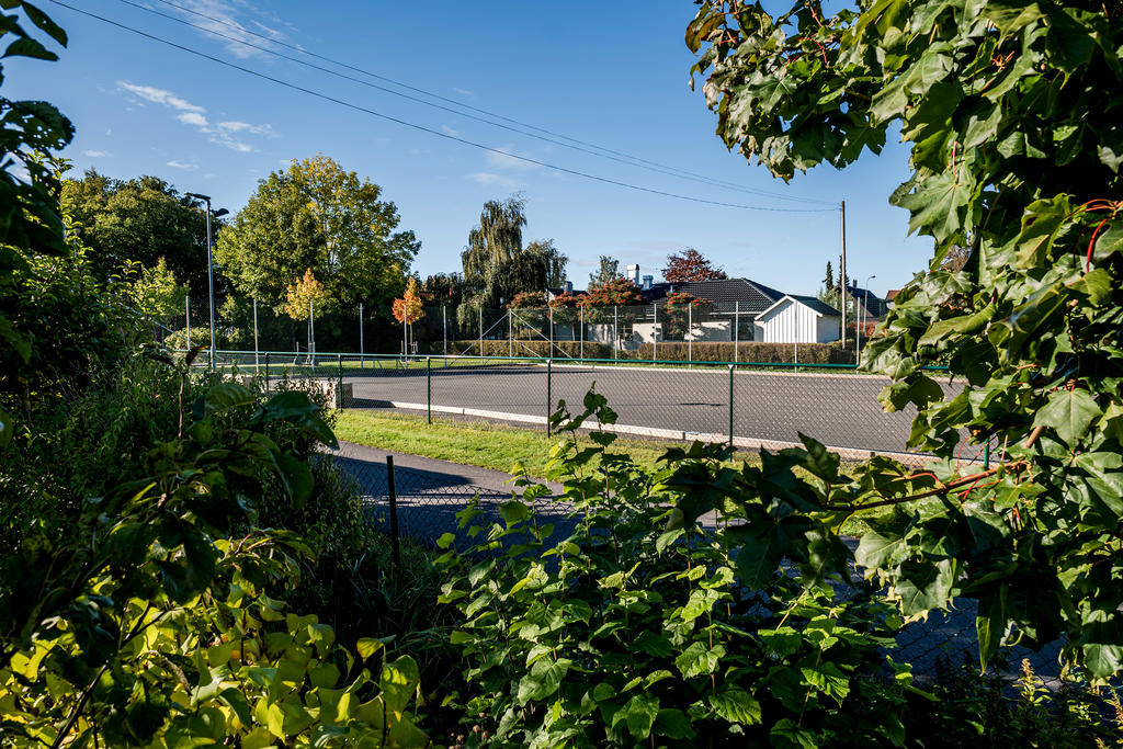 Intill huset finns tennisplan och lekytor