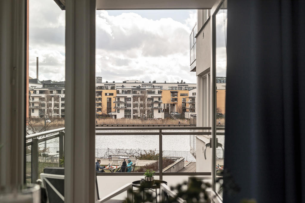Från vardagsrummet finns direkt anslutning ut mot balkongen där blicken riktas mot Hammarby sjös blänkande vatten