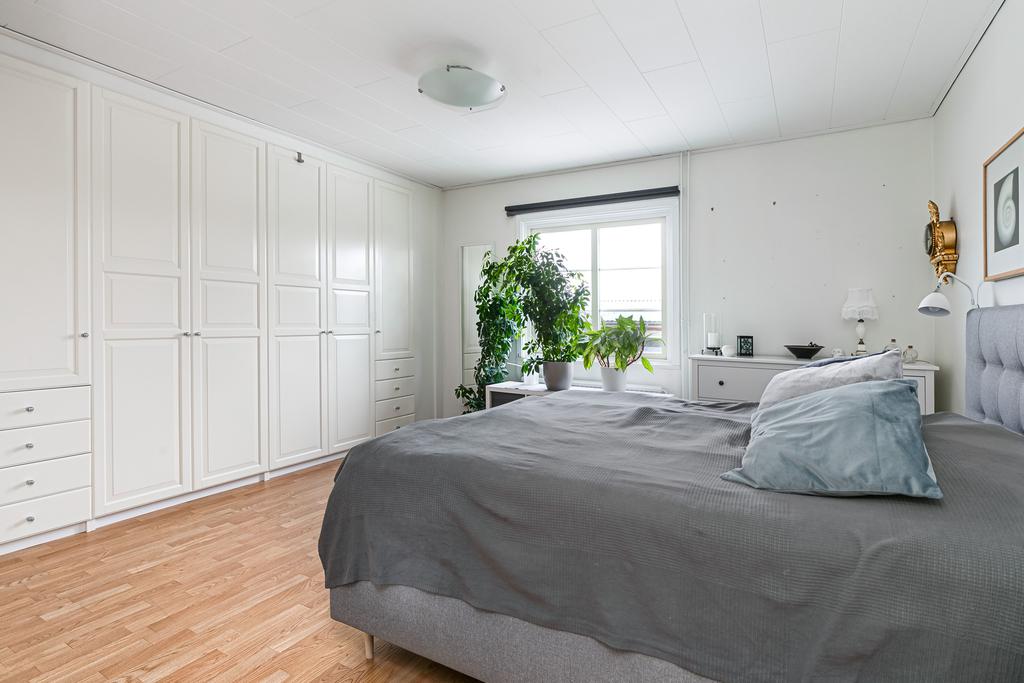 Stort sovrum med en hel garderobsvägg