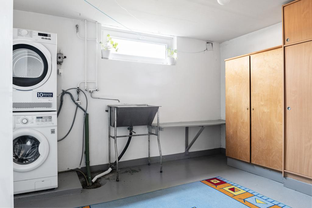 Tvättstuga med tvättmaskin och torktumlare på källarplan.