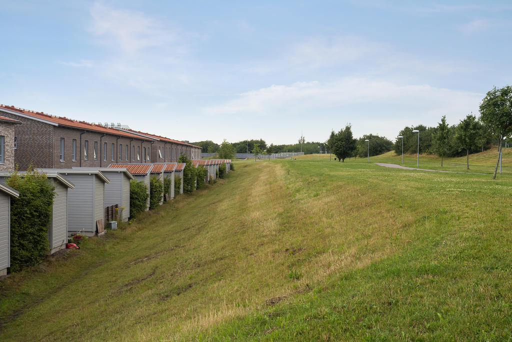 Baksidan med grönytor, cykel- och ridväg. 