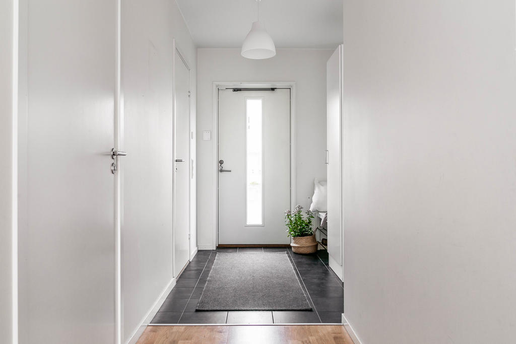 Hall med klinkergolv och garderob. 