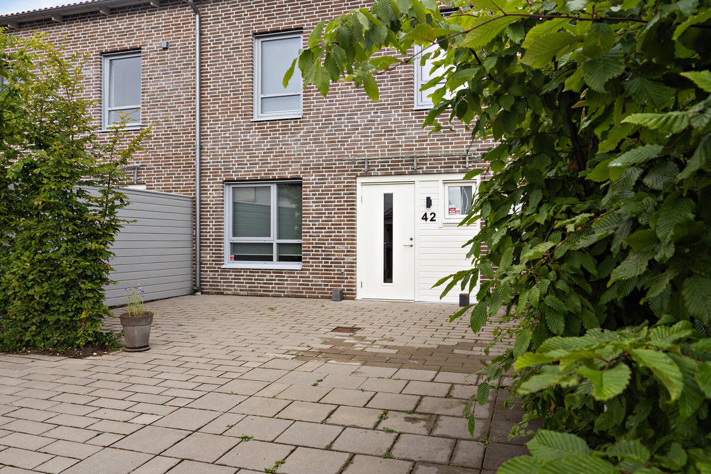 Entrésidan med privat parkering och plats till uteplats. 