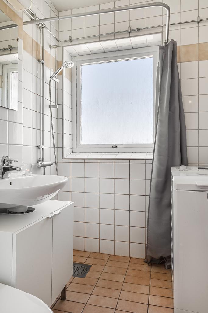 Helkaklat badrum med fönster som bidrar till ett härligt ljusinsläpp