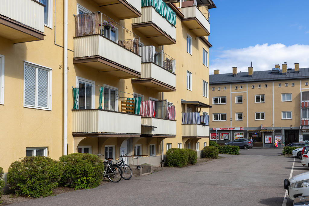 Föreningens innergård med parkeringsplatser och ingång till källare med förråd och tvättstuga. 