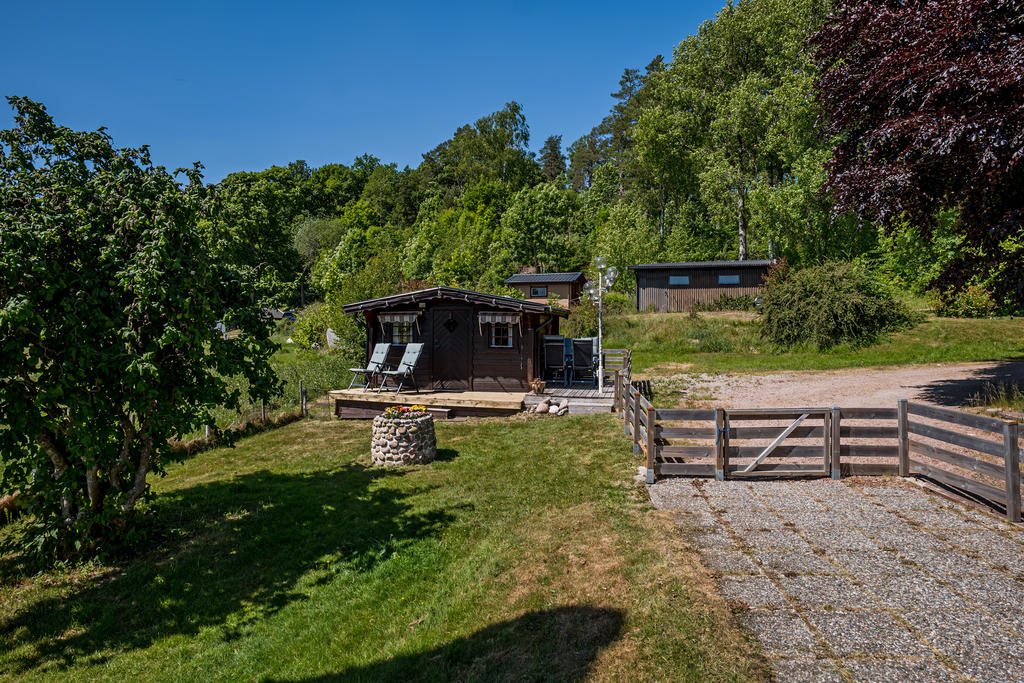 Vy mot gäststuga, carport och vedförråd