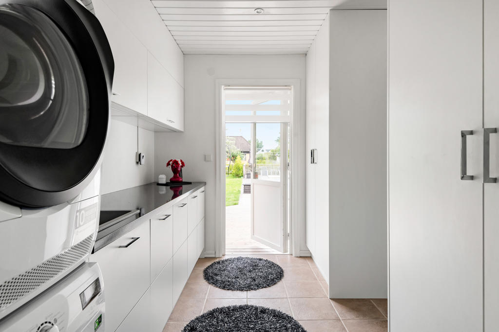 Tvättstuga med utgång till både pool och garage/förråd 