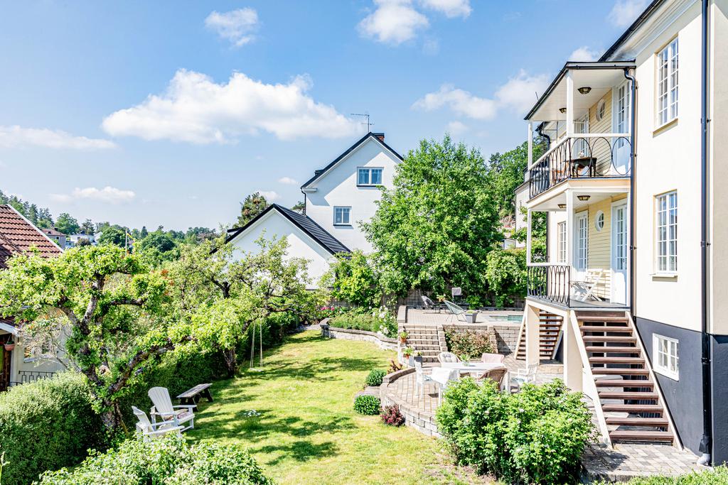 Fint anlagd trädgård med stenläggningar, planteringar och odlingsmöjligheter. 